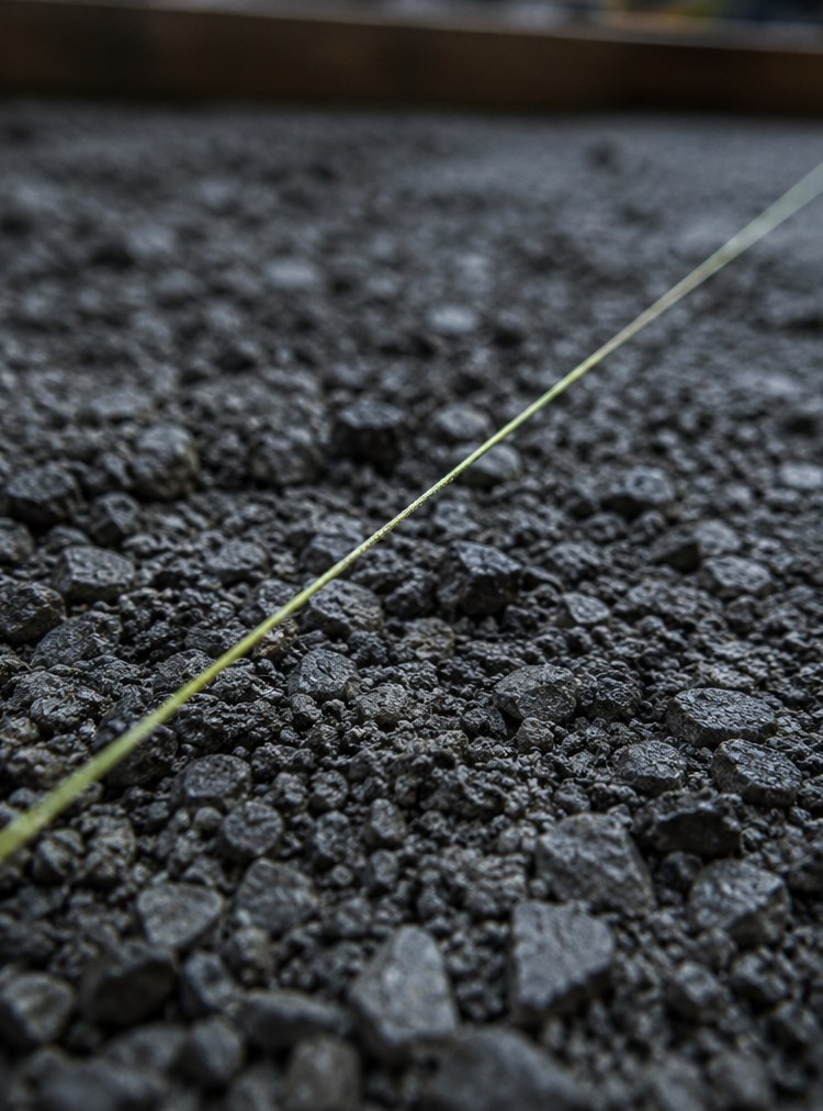 A string line marking grade over a compacted gravel base