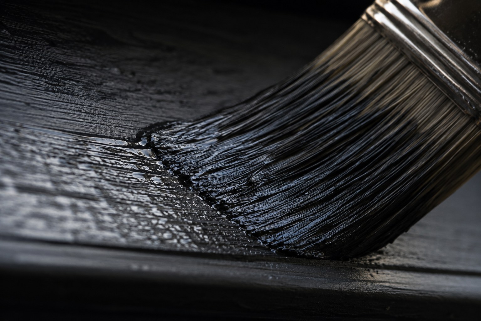 Close detail of a paintbrush stroke on dark exterior trim