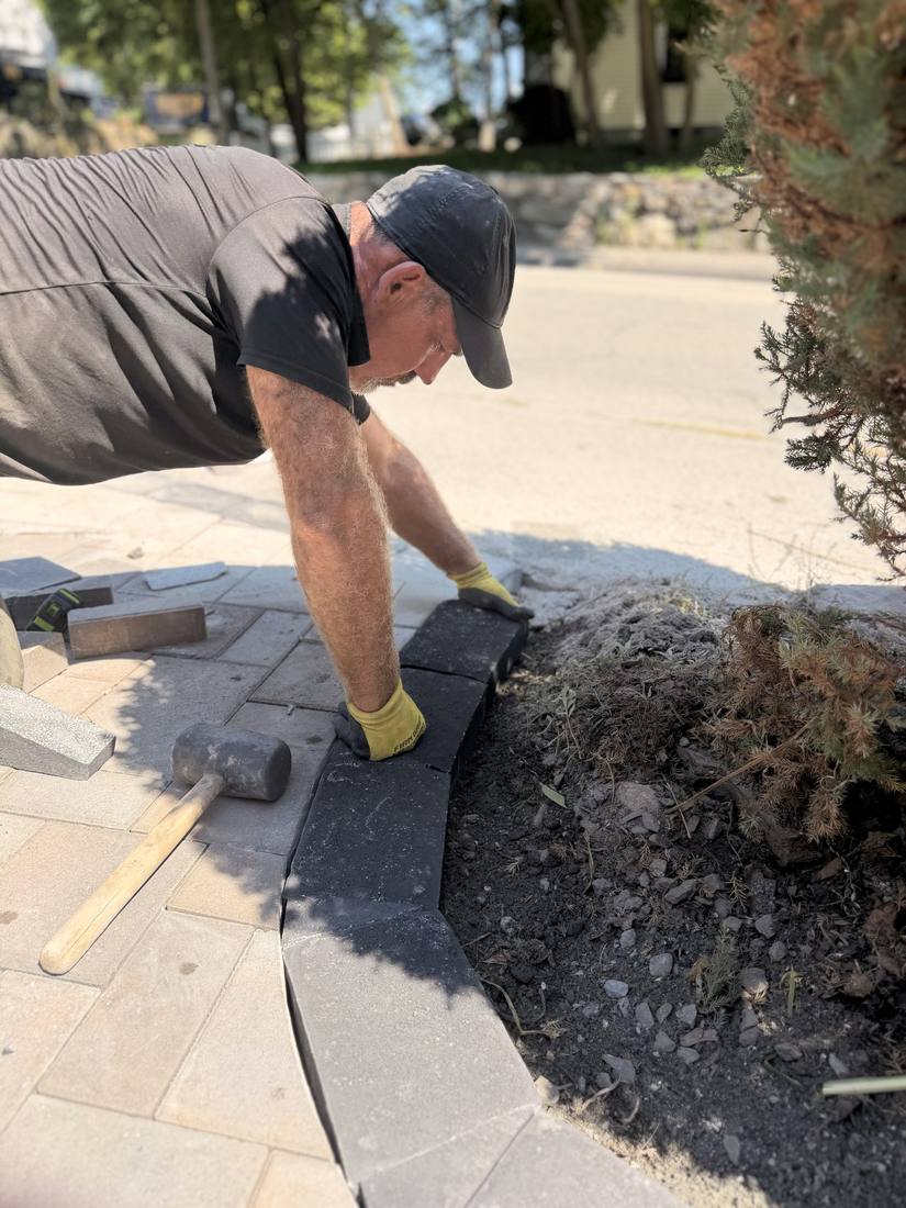 Pavers set by hand and cut to fit, locked in with a restrained edge