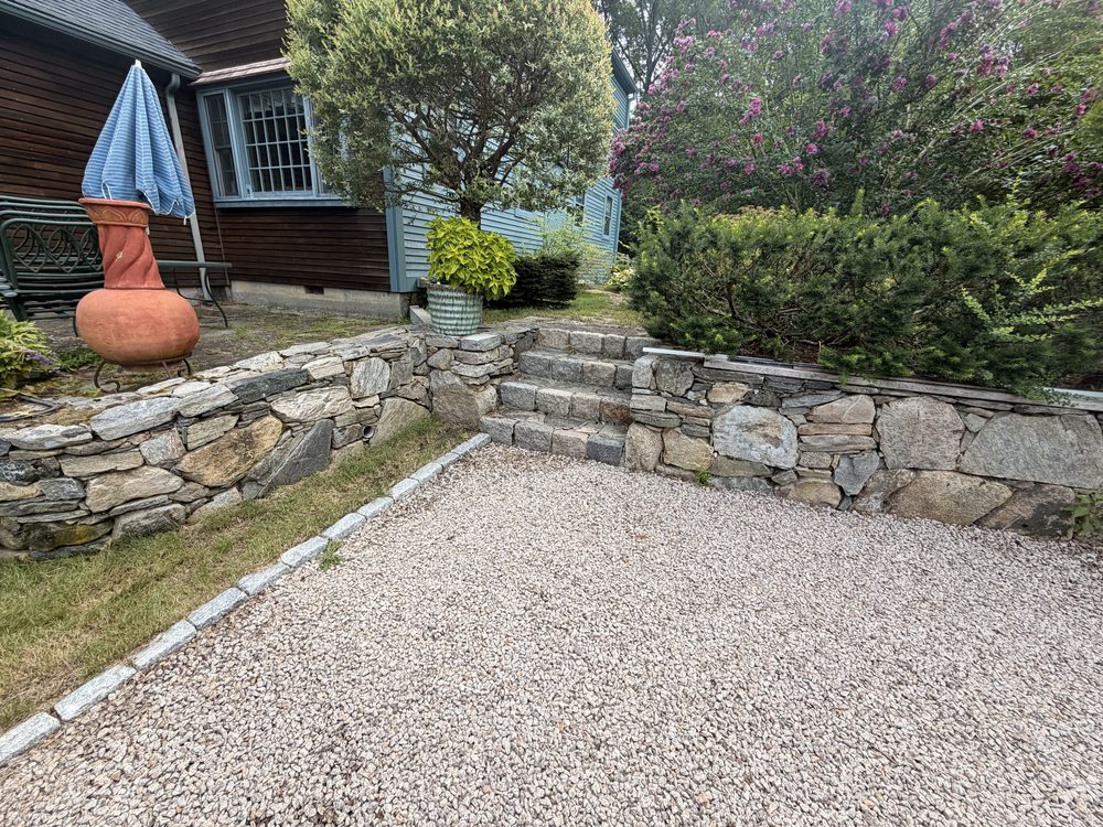 Before — the old steps and low walls seen across the gravel driveway