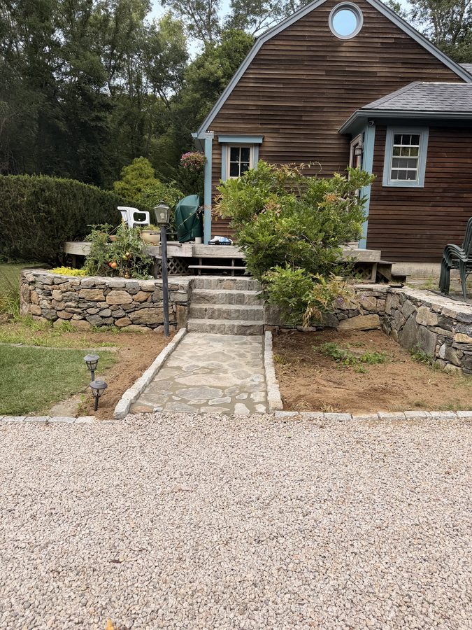 The finished flagstone walk seen from the driveway, running to the steps and the deck