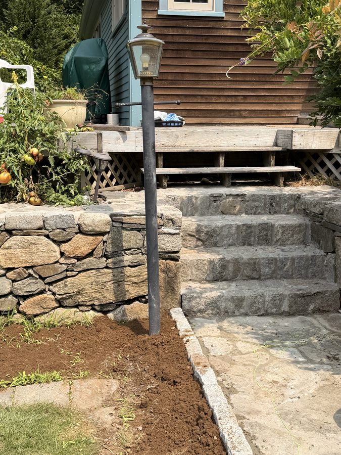 Granite steps rising to the deck, the fieldstone wall carrying them either side