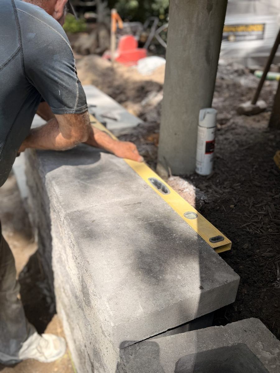 Levelling a cap stone along the wall